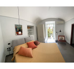Seconda camera matrimoniale Casa Pontano con soffitto a volta e accesso diretto al giardino.