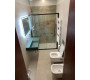 Bagno completo ad uso esclusivo della seconda camera matrimoniale: lavabo moderno e doccia con rivestimento d'effetto.